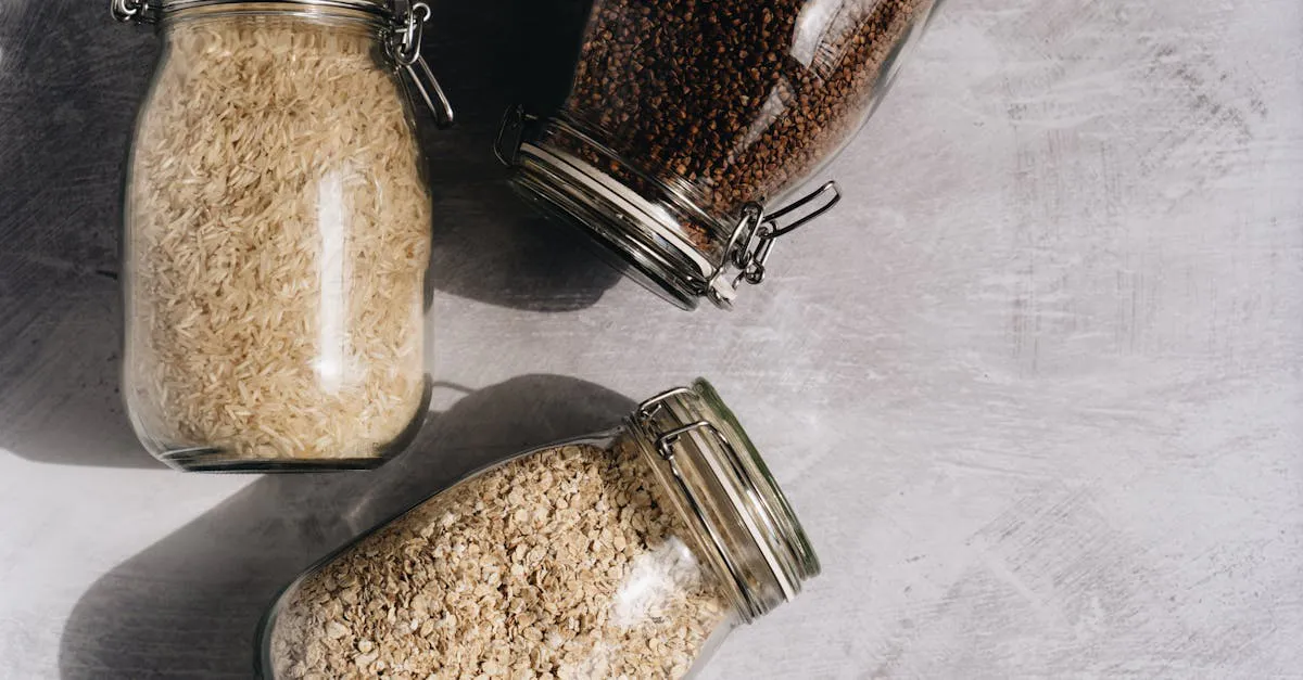 Overhead view of glass jars filled with white rice, rolled oats, and buckwheat on a counter